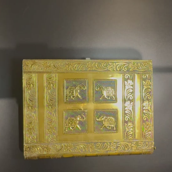 video of opening the gold vintage Indian Jewelry box that shows how the trays fan out and the dowel for bangles is removed. It also shows the latch that closes the box and the edge of the book like design