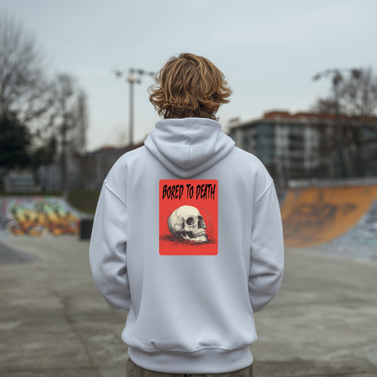 Person wearing a white hoodie with a skull design and 'Bored to Death' text on the back, standing in an urban setting.