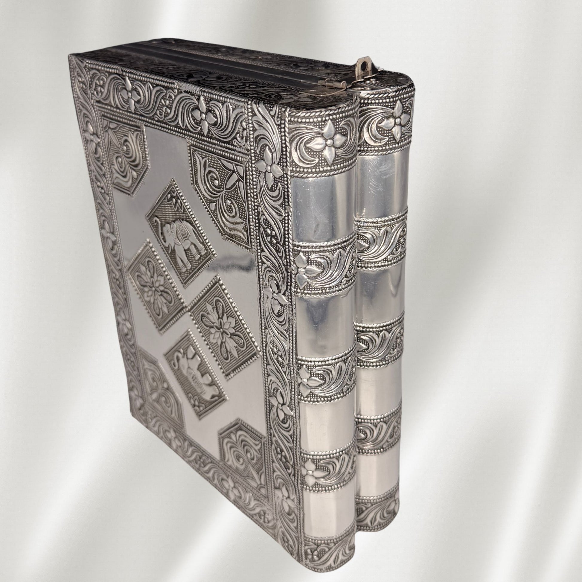 An ornate antique-style silver jewelry box with embossed elephant and floral motifs shown standing upright 