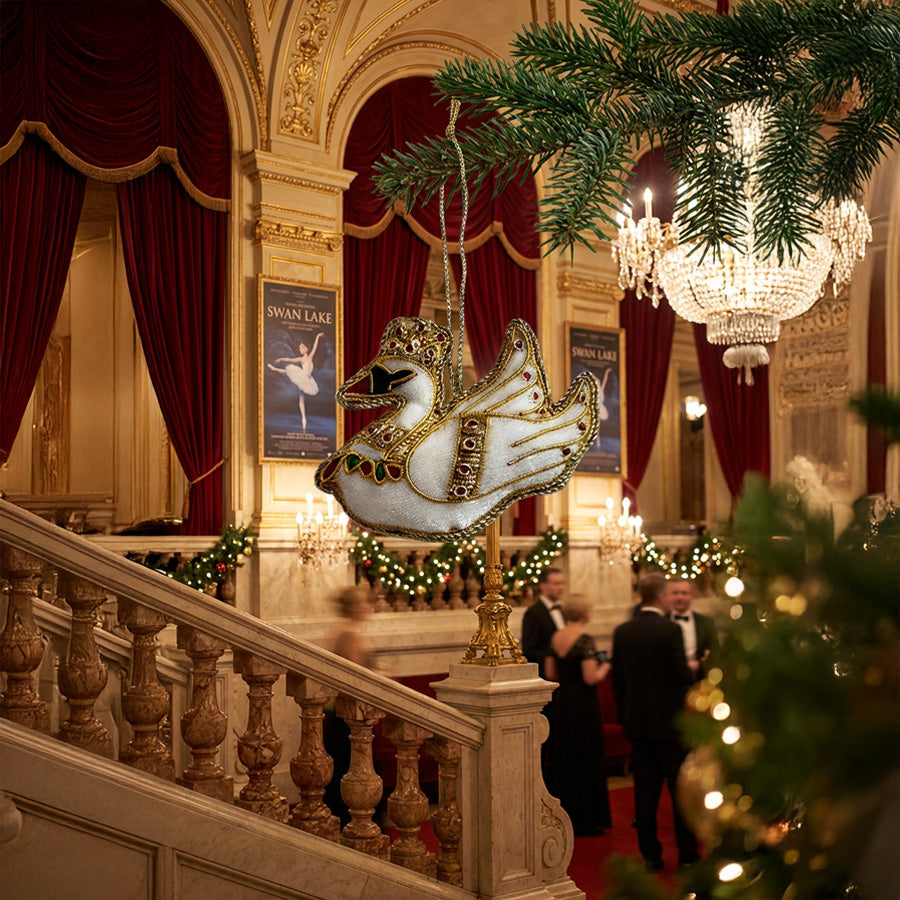 white swan christmas tree ornament hanging on a tree branch in the lobby of a ballet performance hall